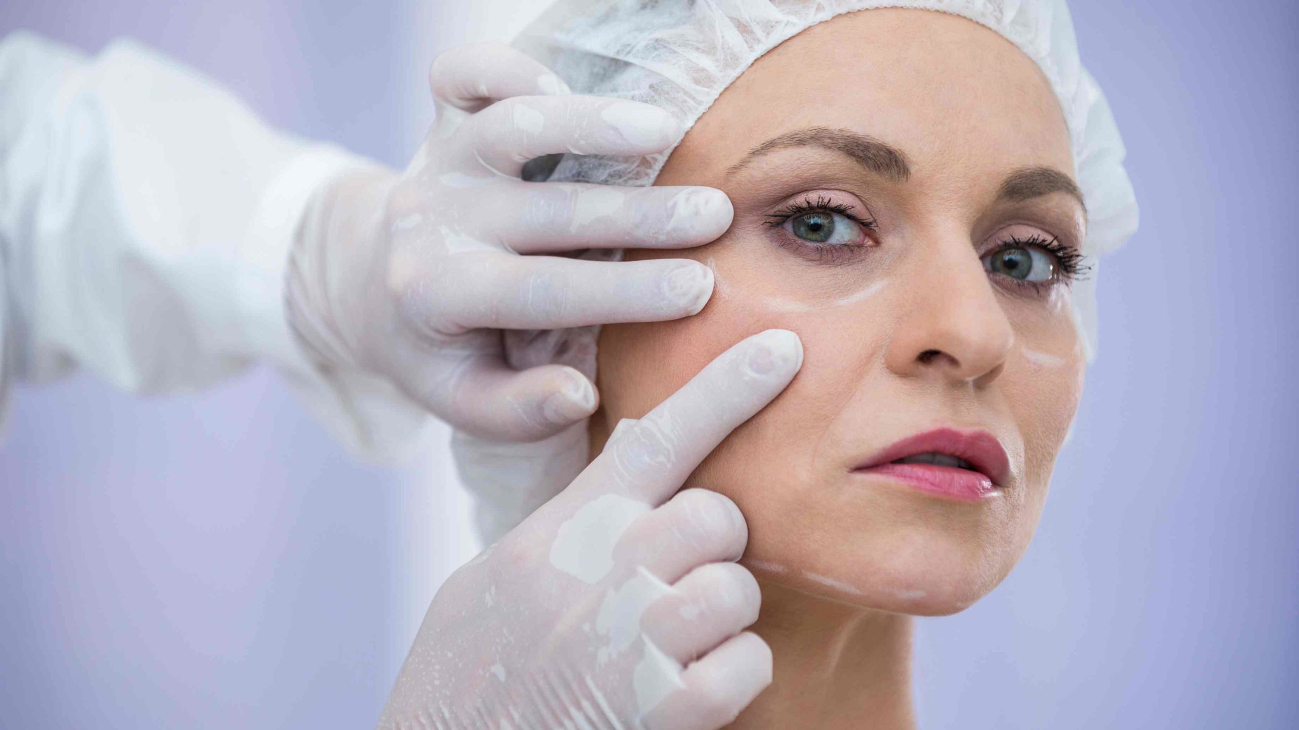 Close-up of doctor examining female patients face for cosmetic treatment